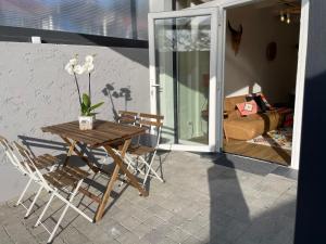 a table and chairs on a porch with a table and flowers at Grand studio avec terrasse Capbreton Wifi, Netflix in Capbreton