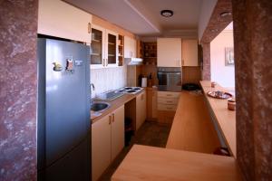 a small kitchen with a stainless steel refrigerator at Apartman 23 in Lazarevac +9 photos