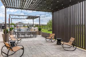 a patio with chairs and a table and a table and chairsktop at Staybridge Suites Grand Prairie Near Epic Central by IHG in Grand Prairie