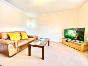 エルギンにある100 Thornhill Drive, Elginのソファと薄型テレビのあるリビングルーム +7枚の写真