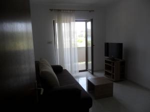 a living room with a couch and a television at Apartment in Palit with sea view, balcony, Wi-Fi (4606-2) in Mundanije