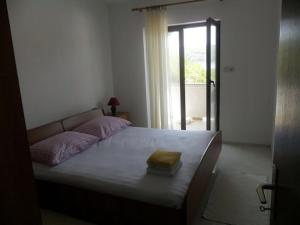 a bedroom with a bed and a door with a window at Apartment in Palit with sea view, balcony, Wi-Fi (4606-2) in Mundanije