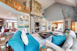 een woonkamer met een blauwe bank en een stenen open haard bij Stone Creek Retreat in Cape Neddick