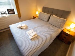 a bedroom with a large bed with two towels on it at Hafan in Llangollen