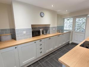 a kitchen with white cabinets and a counter top at Minafon in Llangollen