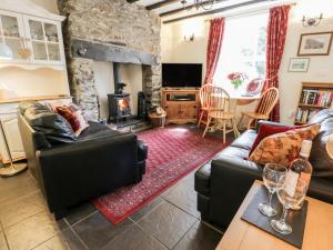 a living room with a couch and a fireplace at Bwthyn Afon River Cottage in Blaenau-Ffestiniog