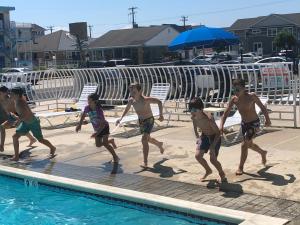 un grupo de niños jugando en una piscina en Gold Crest Motel, en Wildwood Crest