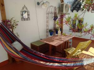 a hammock in a room with a table and chairs at La Puerta Azul in Bornos