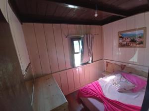 a small pink room with a bed and a window at Casa de Campo da Vó in Urupema +58 photos