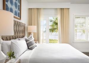 una camera bianca con un grande letto e una finestra di Parrot Key Hotel & Villas a Key West