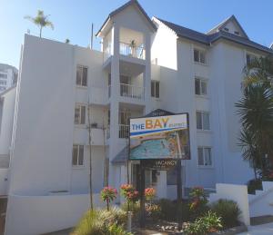 a large white building with a sign in front of it at The Bay Apartments Coolangatta in Gold Coast