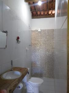 a bathroom with a sink and a toilet and a shower at Pousada Várzea da Serra in Jaboticatubas