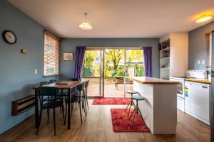 a kitchen with a table and chairs and a dining room at 5 Amuri Avenue in Hanmer Springs