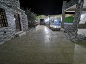 a walkway leading to a tunnel at night at Villa Salassel Al Jabal Al Akhdar فلة سلاسل الجبل الأخضر in Al ‘Ayn