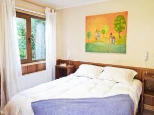 a bedroom with a bed and a painting on the wall at Amadeus Hotel Boutique in Frutillar