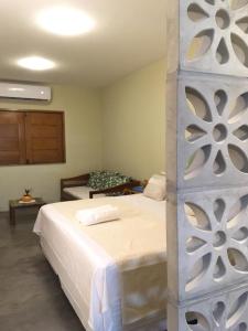 sypialnia z dużym białym łóżkiem w pokoju w obiekcie Quintal de Areias w mieście Santo Amaro