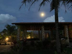 a house with a palm tree and a full moon at Quintal de Areias in Santo Amaro