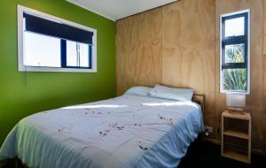 um quarto verde com uma cama e uma janela em Scott Base - National Park Holiday Home em National Park