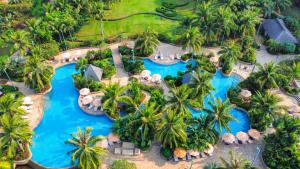 an aerial view of a resort pool with palm trees at Shangri-La Haikou in Haikou