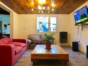 uma sala de estar com um sofá e uma mesa de centro em Ciao Bariloche - habitaciones privadas en hostel em San Carlos de Bariloche