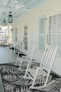 two white chairs sitting on a porch with a rug at The Porch on Frances Inn - Adults Exclusive in Key West