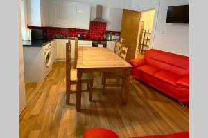 cocina con mesa de madera y sofá rojo en 300 yards from Old course and St Andrews centre en St Andrews