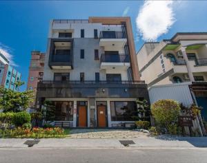 花莲市花蓮前站-艾莉小屋電梯民宿的一座高大的建筑,在城市里装有橙色门