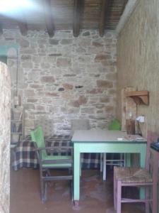 tavolo e sedie in una stanza con parete in pietra di Stoneworld a Evdilos