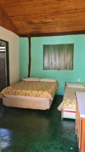 2 łóżka w pokoju z niebieskimi ścianami w obiekcie Chacara bica dágua w mieście Pirenópolis