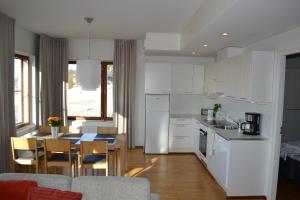 a kitchen and dining room with white cabinets and a table at Ylläs Chalets A9206 Talvikaudelle 25-26 hinta sisältää 2kpl hissilippuja! in Ylläsjärvi