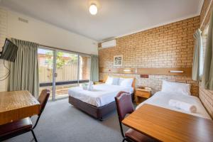 um quarto de hotel com duas camas e uma janela em Colac Mid City Motor Inn em Colac