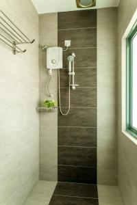 een badkamer met een douche met een douchekop bij Luma Casa Capsule Hotel, Sunsuria Forum Setia Alam in Shah Alam