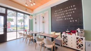 a dining room with tables and chairs and a chalkboard at Angel Inn in Hualien City