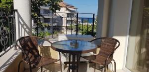 una mesa y sillas en un balcón con vistas al océano en MIDA Apartment en Obzor