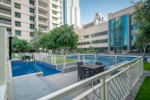 a balcony with a table next to a swimming pool at BellaVista 29 Boulevard 2 Bedroom Burj Khalifa & Fountain View in Dubai