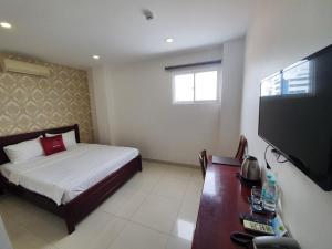 um quarto com uma cama e uma televisão de ecrã plano em Minh Khue Hotel em Vinh Long
