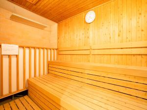 a wooden sauna with a clock on the wall at Tenza Hotel & SKYSPA at Sapporo Central in Sapporo