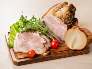a cutting board with meat and vegetables on it at Tenza Hotel & SKYSPA at Sapporo Central in Sapporo