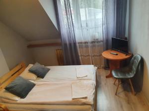 1 dormitorio con 1 cama y escritorio con ordenador en U Joanny, en Piaseczno