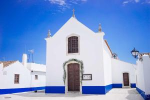 a white church with a cross on top of it at GreenEscapes II in Porto Covo