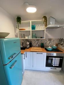 a kitchen with a blue refrigerator and white cabinets at Domek InoSasino z basenem i sauną in Sasino