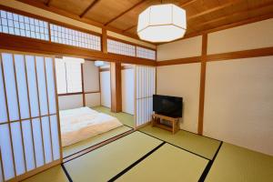 pokój z łóżkiem i telewizorem w obiekcie Manabi-stay Takayama SAKURA 提携駐車場利用可 古い町並みまで徒歩1分 最大9名宿泊可能な一等地で人工温泉を楽しむ w mieście Takayama