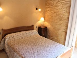 een slaapkamer met een bed en een lamp op een tafel bij Gîte Salignac-Eyvigues, 4 pièces, 6 personnes - FR-1-616-88 in Salignac Eyvigues