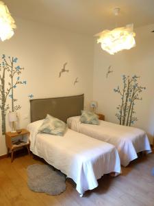 ラ・スペツィアにあるAffittacamere I Gatti delle 5 Terreのベッド2台 鳥の壁が備わる客室です。