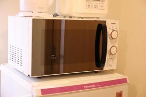 a microwave oven sitting on top of a shelf at ケイアイコンホテルズ 新栄301 in Aoichō