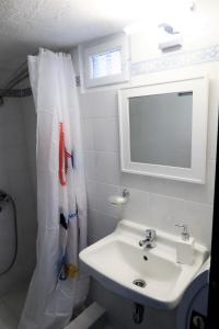 y baño con lavabo y espejo. en Stella's Home in Koronos, en Kóronos