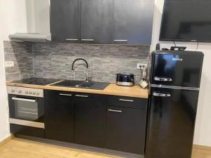 a kitchen with a black refrigerator and a sink at Apartma Šelih Mandre - Pag in Mandre +11 photos