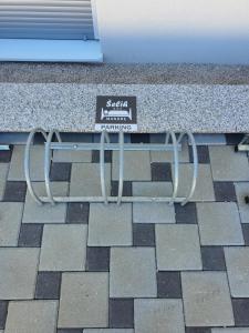 a bench with a sign on it sitting on a sidewalk at Apartma Šelih Mandre - Pag in Mandre