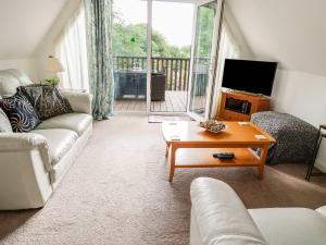 a living room with a couch and a tv and a table at 19 Honicombe Park in Callington