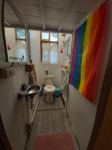 baño con bandera de arco iris en la pared en Here Sleep Guesthouse en Kaohsiung